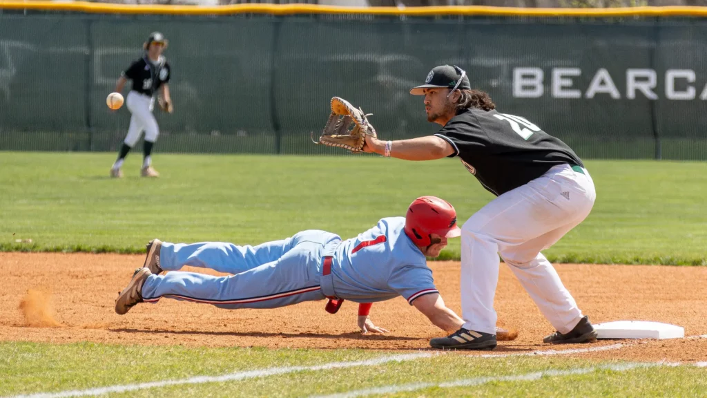 Bearcat baseball infielder Kaehukai Young attempts to tag out a player at first base.