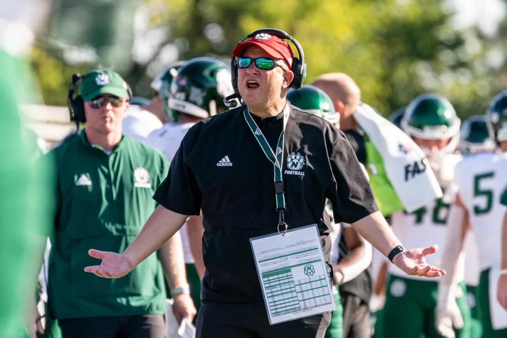 Bearcat football coach Rich Wright holds his arms out in frustration at a penalty call.